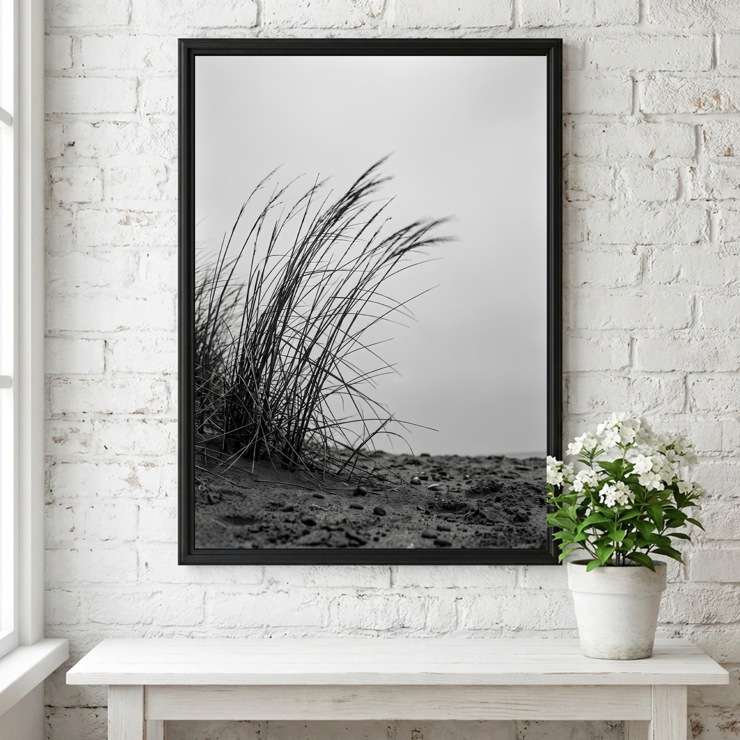 Black and white poster showing dune grass bending in wind on sandy ground with soft shadows