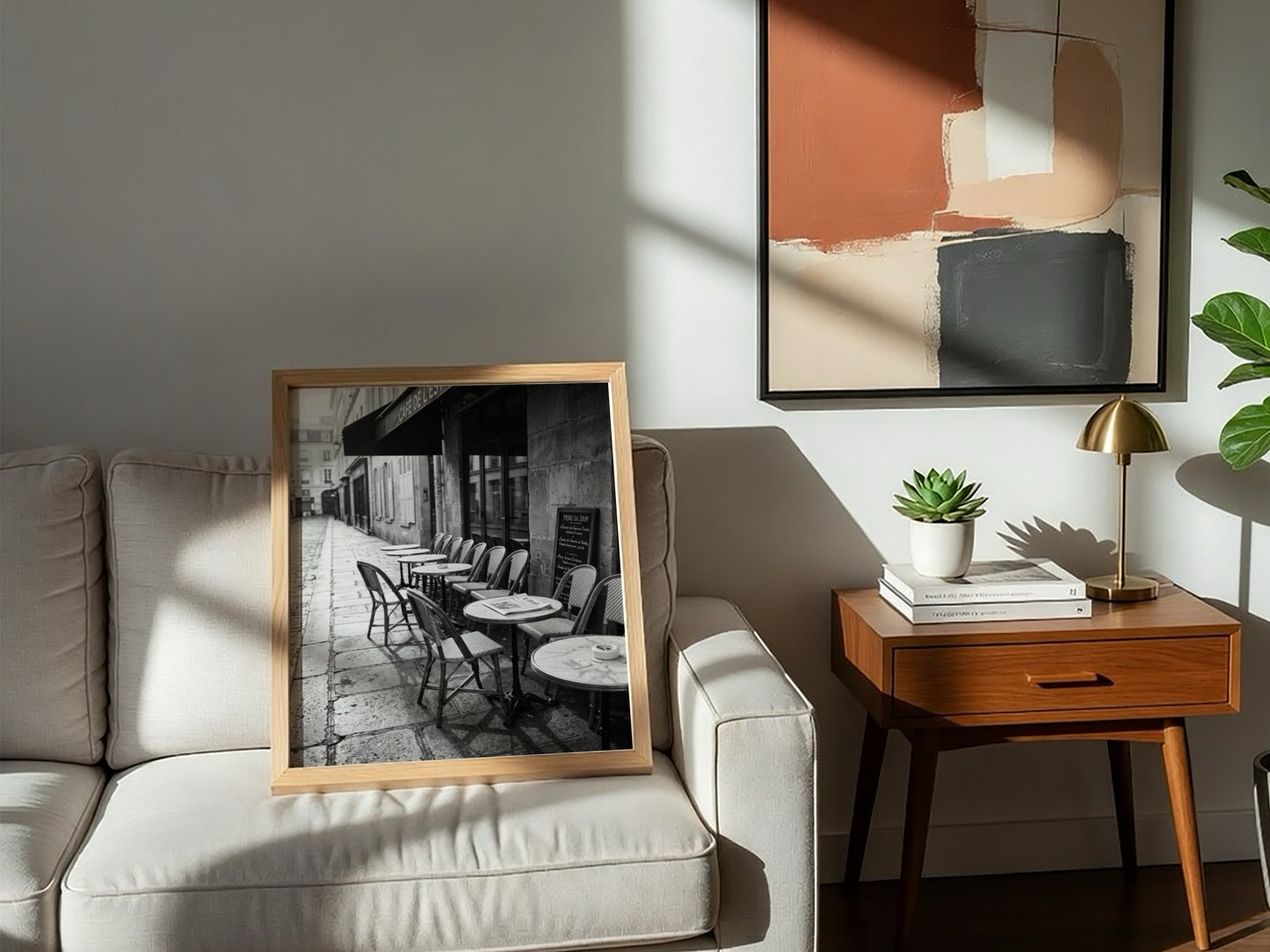 Black and white wall decor featuring empty Parisian cafe terrace with chairs and tables on cobblestone street