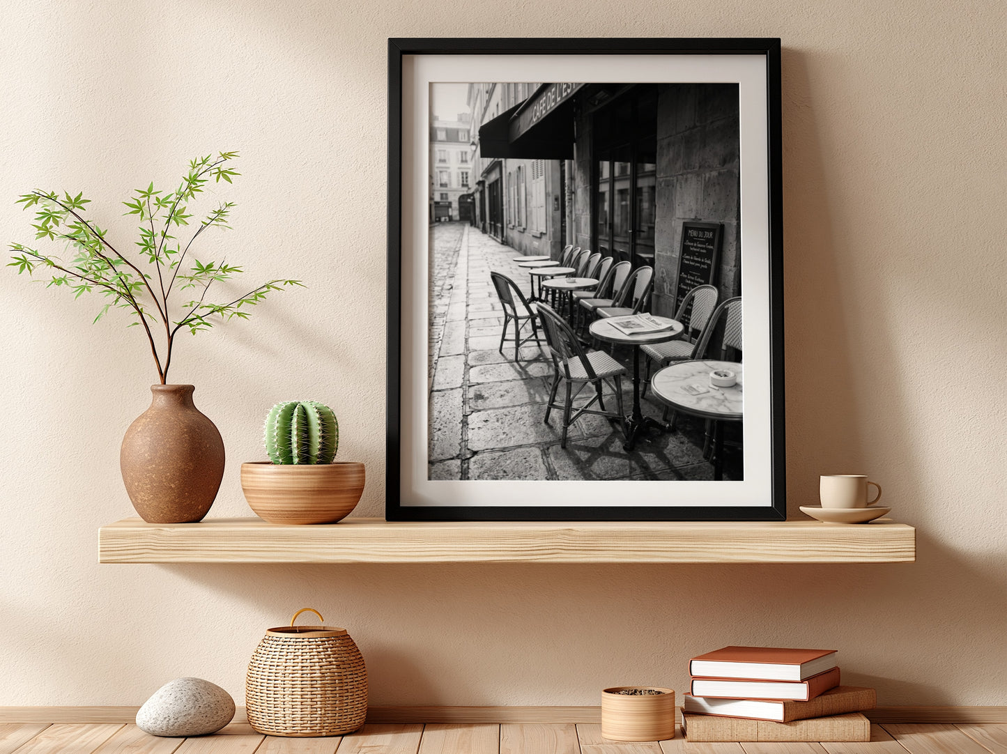Black and white wall decor featuring empty Parisian cafe terrace with chairs and tables on cobblestone street