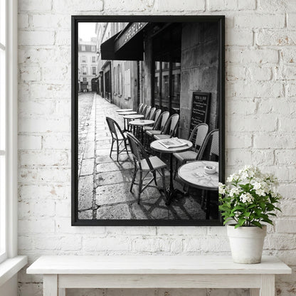 Black and white wall decor featuring empty Parisian cafe terrace with chairs and tables on cobblestone street