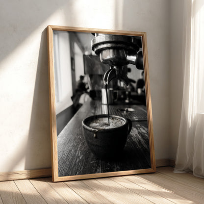 Black and white poster showing espresso pouring from coffee machine into cup on wooden surface