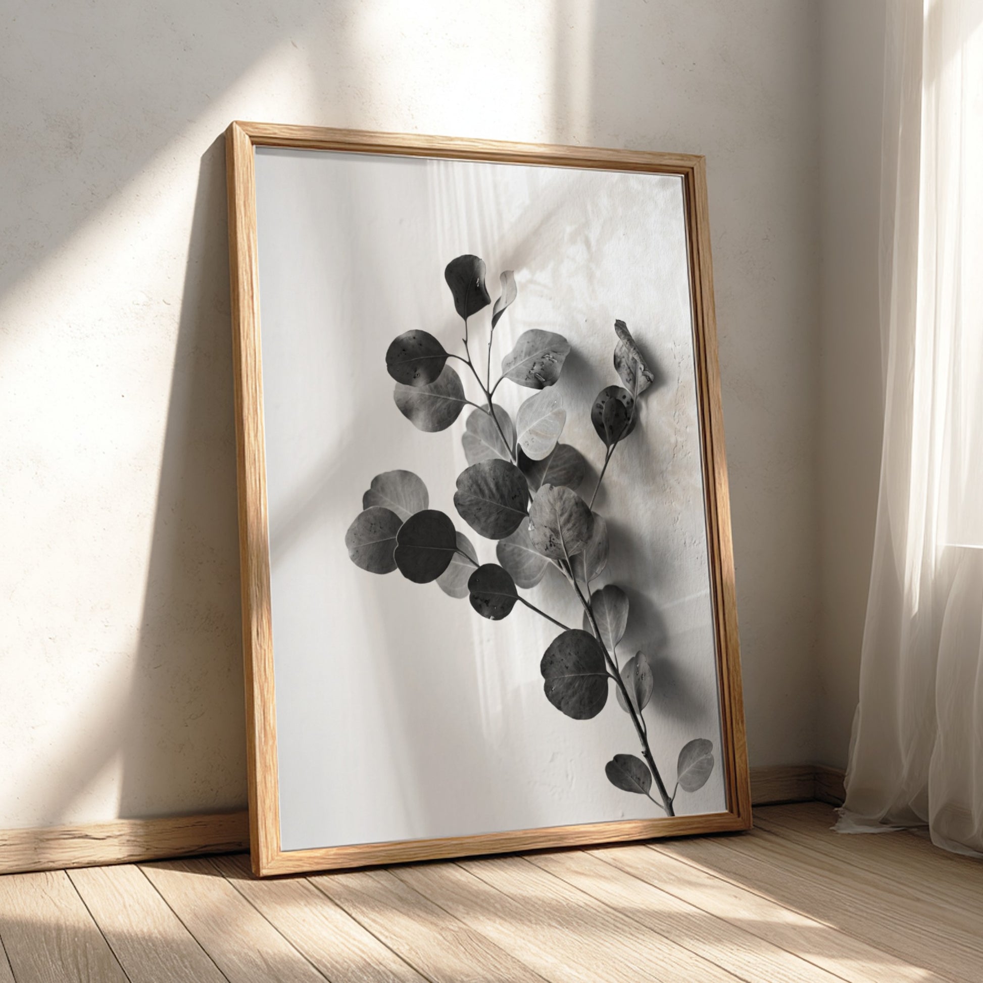 botanical wall decor featuring grayscale eucalyptus branch with rounded leaves on white background