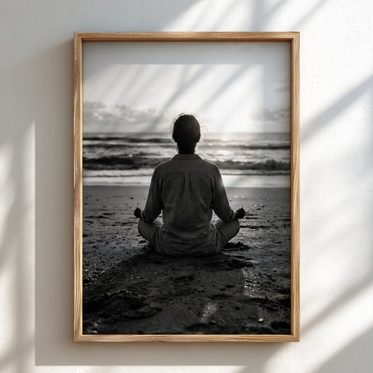 black and white wall decor showing figure meditating on beach at sunrise with ocean waves