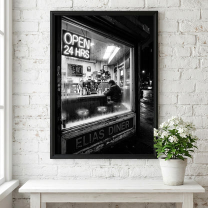 Poster of black and white diner interior with neon open 24 hrs sign and lone figure sitting