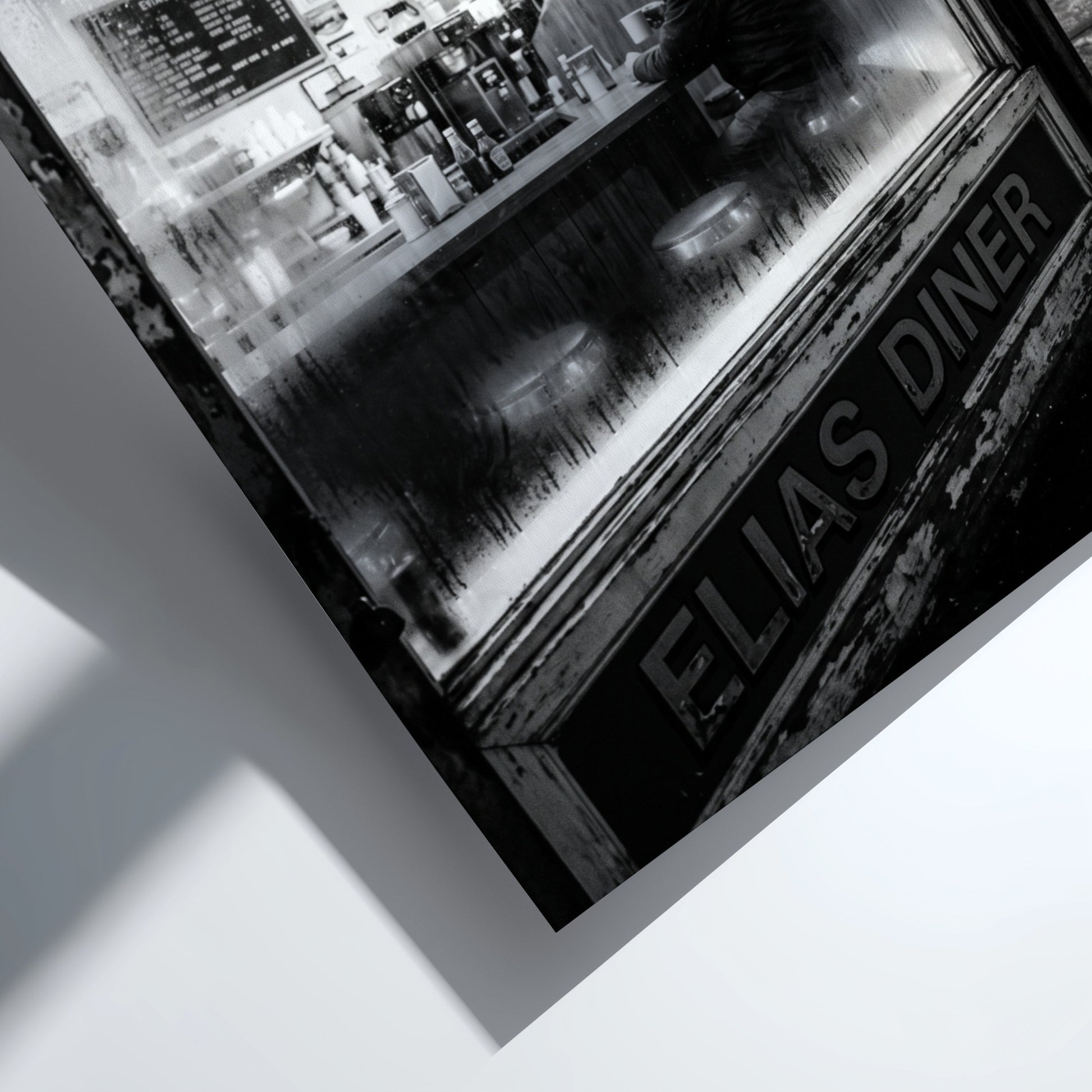 Poster of black and white diner interior with neon open 24 hrs sign and lone figure sitting
