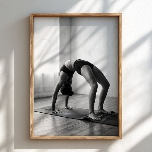 Black and white poster of figure stretching in yoga pose on mat in minimalist room