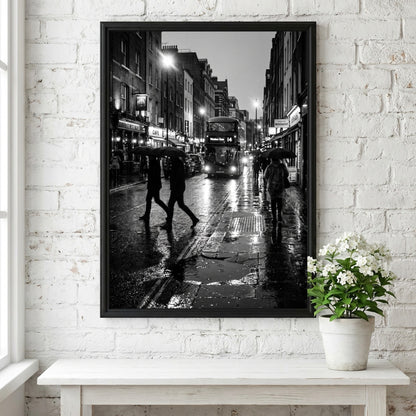 black and white wall decor showing figures walking on rainy city street with umbrellas and double-decker bus