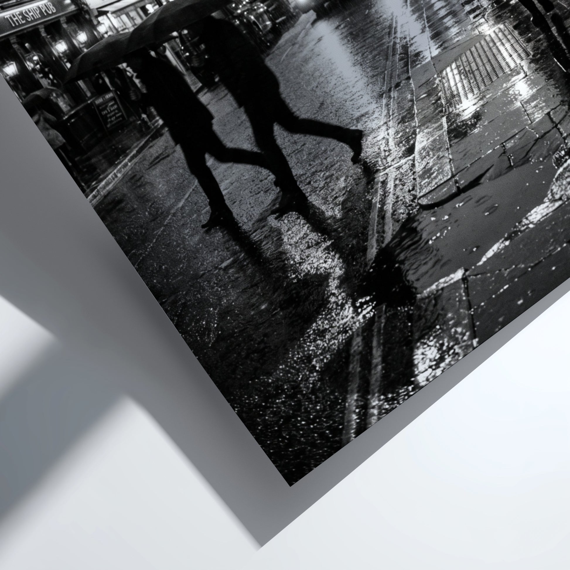 black and white wall decor showing figures walking on rainy city street with umbrellas and double-decker bus