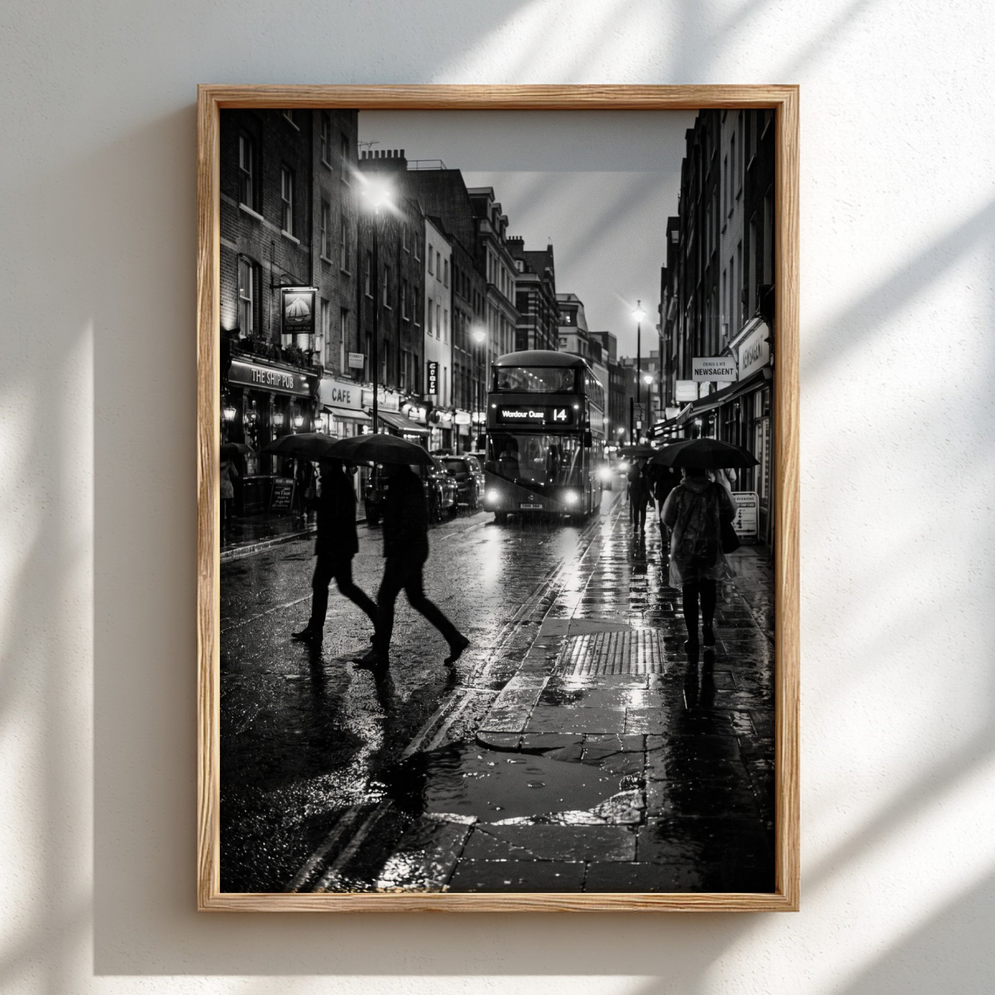 black and white wall decor showing figures walking on rainy city street with umbrellas and double-decker bus