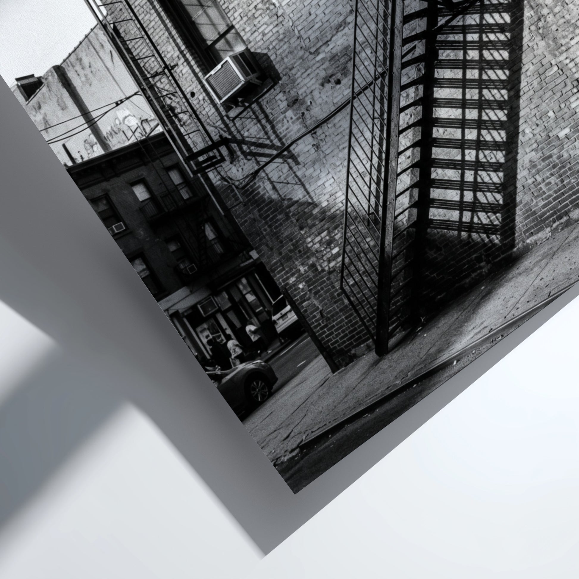 black and white wall decor showing fire escape on brick building with strong shadows