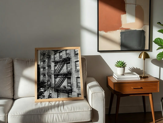 black and white wall decor featuring fire escape on brick tenement building with urban street below
