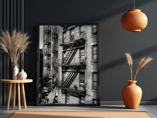 black and white wall decor featuring fire escape on brick tenement building with urban street below