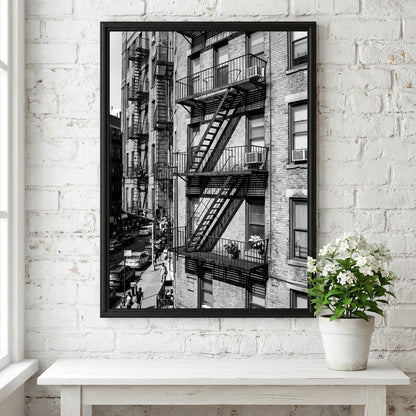 black and white wall decor featuring fire escape on brick tenement building with urban street below