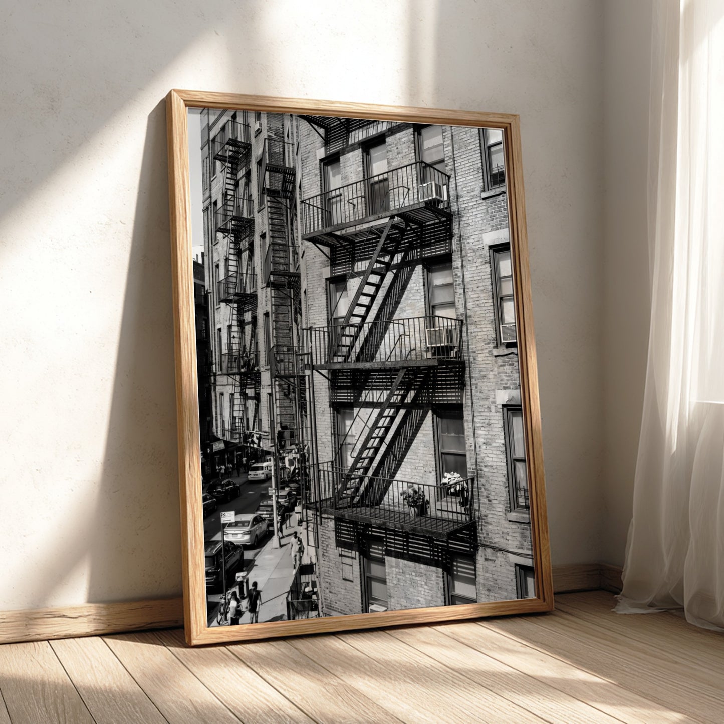black and white wall decor featuring fire escape on brick tenement building with urban street below