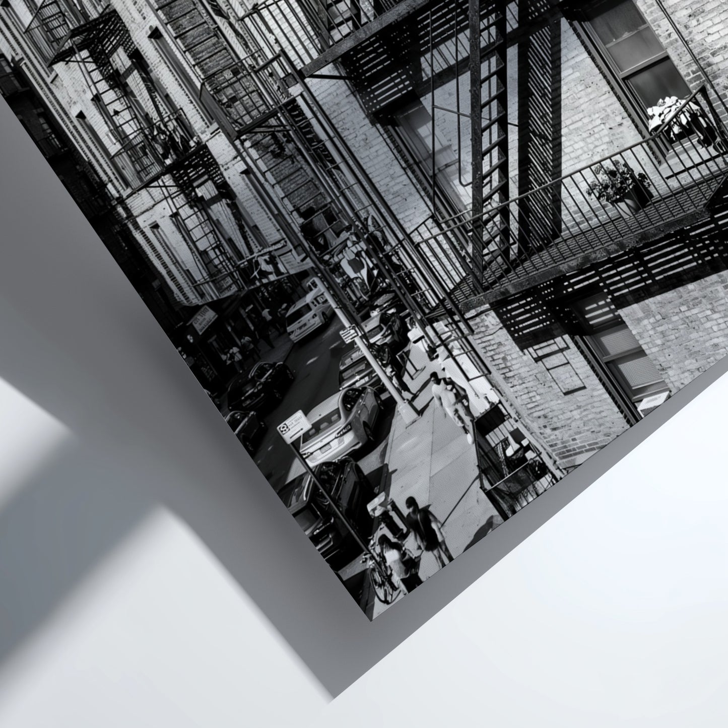 black and white wall decor featuring fire escape on brick tenement building with urban street below
