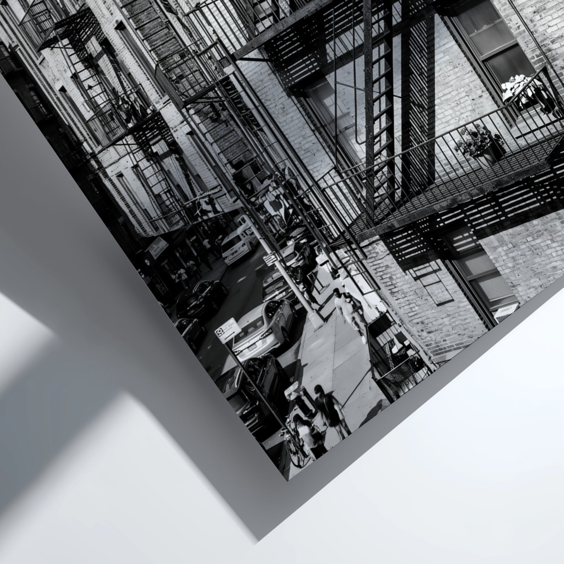 black and white wall decor featuring fire escape on brick tenement building with urban street below