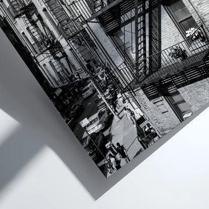 black and white wall decor featuring fire escape on brick tenement building with urban street below