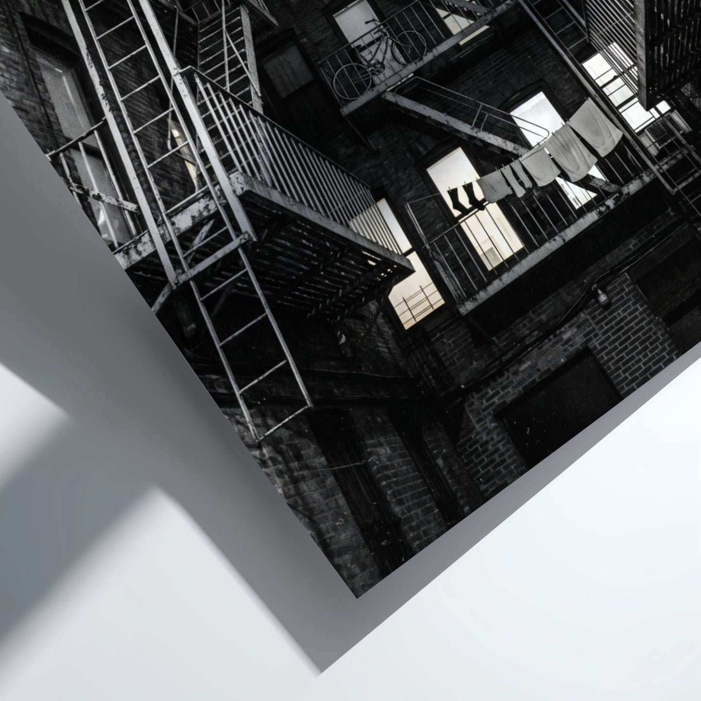Black and white wall decor showing fire escapes on tenement building with geometric patterns and urban