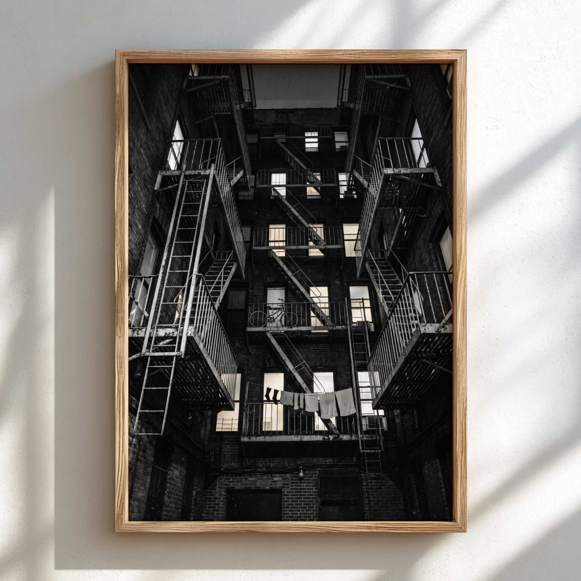 Black and white wall decor showing fire escapes on tenement building with geometric patterns and urban