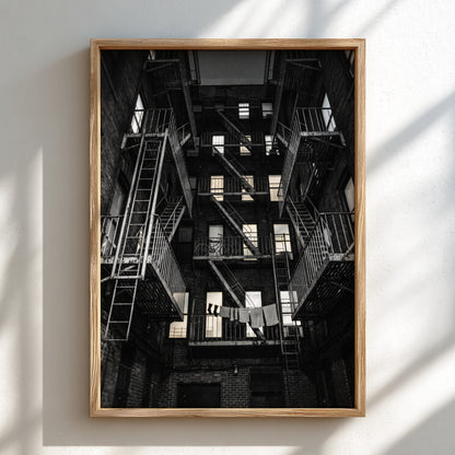 Black and white wall decor showing fire escapes on tenement building with geometric patterns and urban