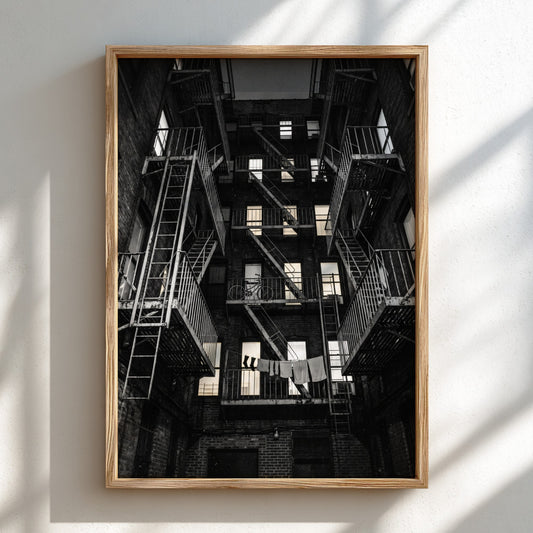 Black and white wall decor showing fire escapes on tenement building with geometric patterns and urban