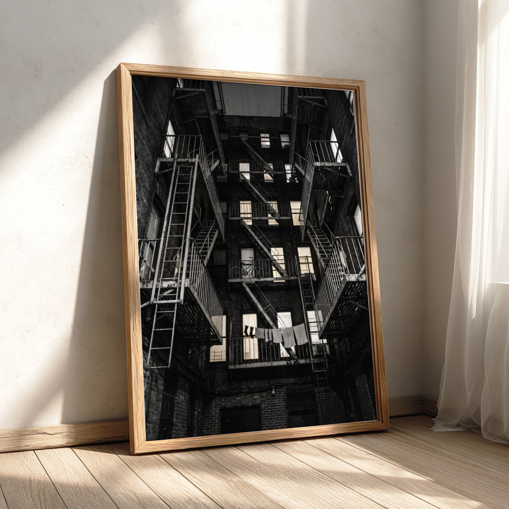 Black and white wall decor showing fire escapes on tenement building with geometric patterns and urban