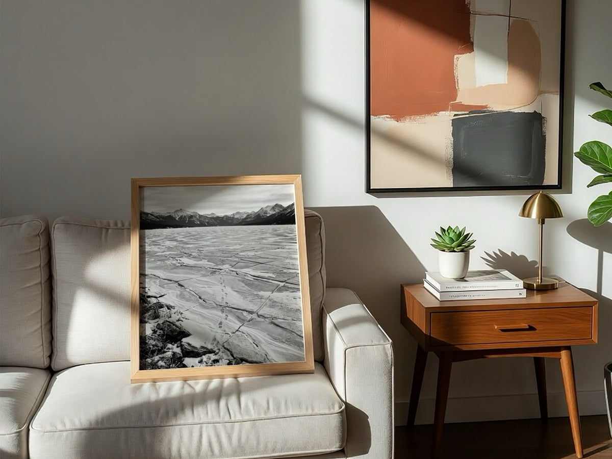 framed wall decor showing footprints crossing frozen lake with cracked ice and mountain background black and