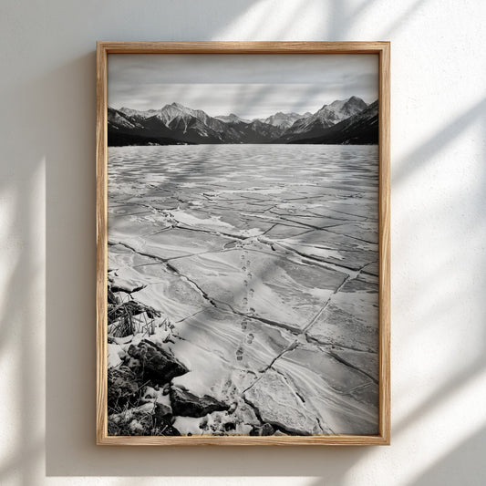 framed wall decor showing footprints crossing frozen lake with cracked ice and mountain background black and