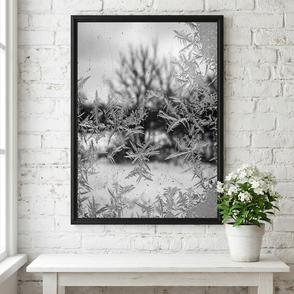 Poster of frost patterns on window with blurred winter trees background in grayscale