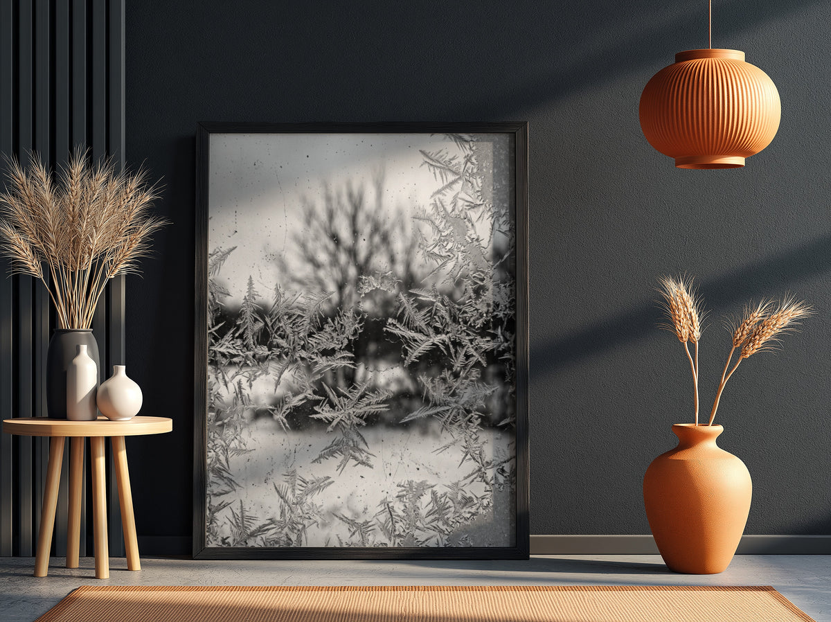 Poster of frost patterns on window with blurred winter trees background in grayscale