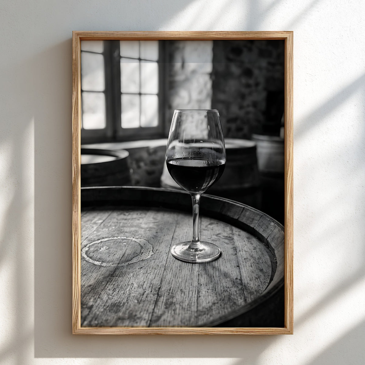 Black and white poster of a glass of wine on wooden barrel with window light shadows