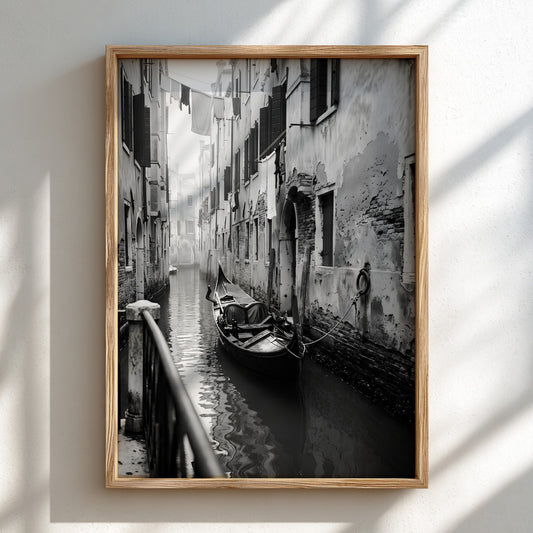 Black and white poster of a gondola moored in a narrow Venetian canal with historic buildings and hanging
