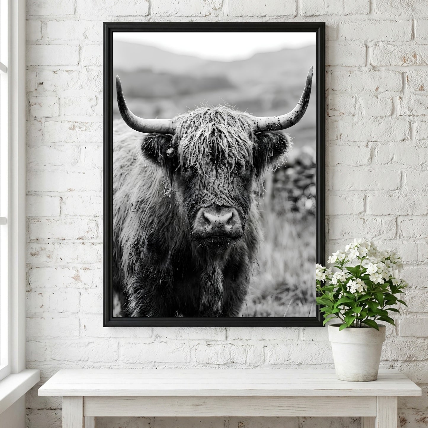 Black and white poster of a highland cow facing camera with shaggy fur and prominent horns