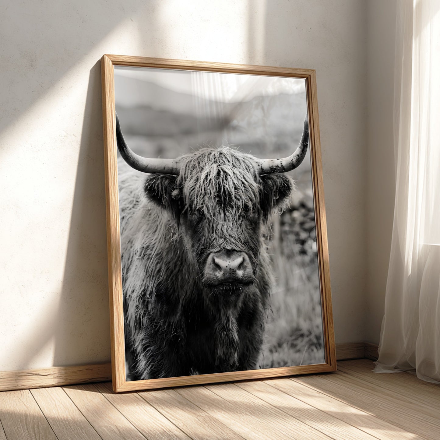 Black and white poster of a highland cow facing camera with shaggy fur and prominent horns