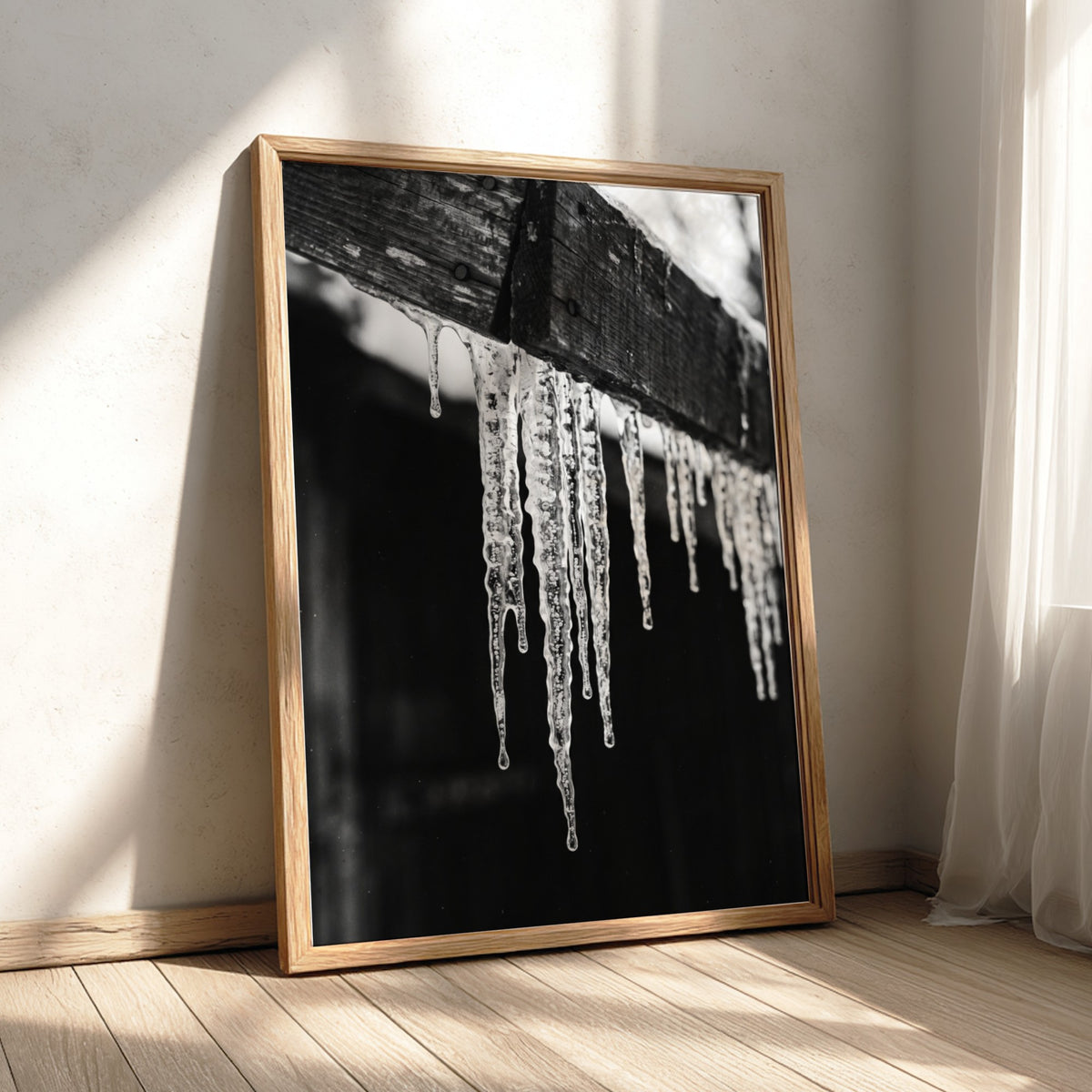 black and white photographic wall decor showing icicles hanging from a wooden eave with dark background