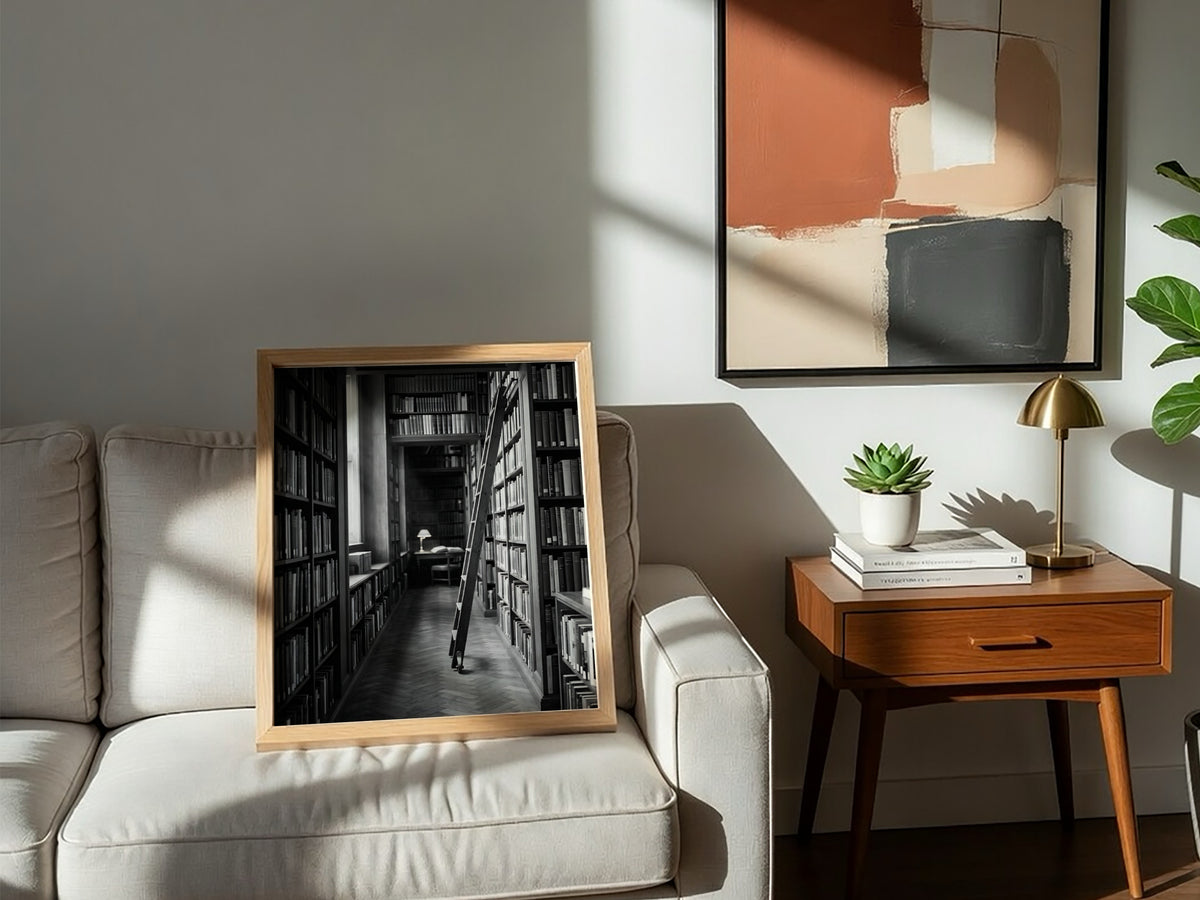 Wall decor featuring black and white photograph of library aisle with ladder and glowing reading lamp