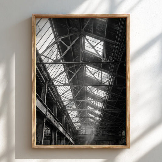 Industrial wall decor showing light streaming through factory roof beams in black and white