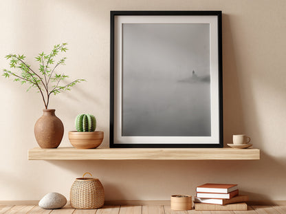 Poster featuring lighthouse emerging from fog in muted grayscale tones with soft shadows