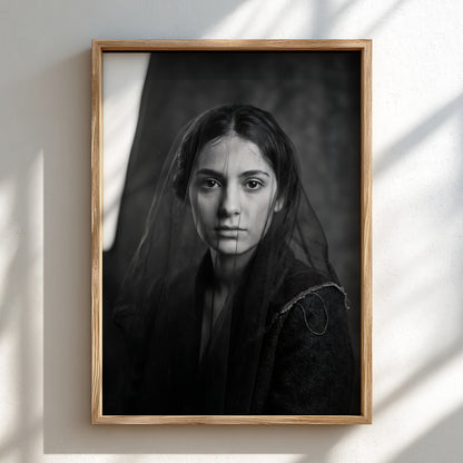 Black and white portrait wall decor of a model behind a sheer veil with soft shadows