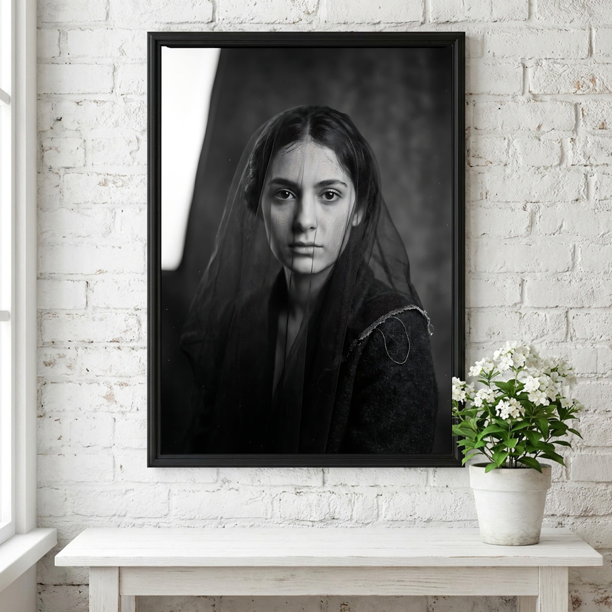 Black and white portrait wall decor of a model behind a sheer veil with soft shadows