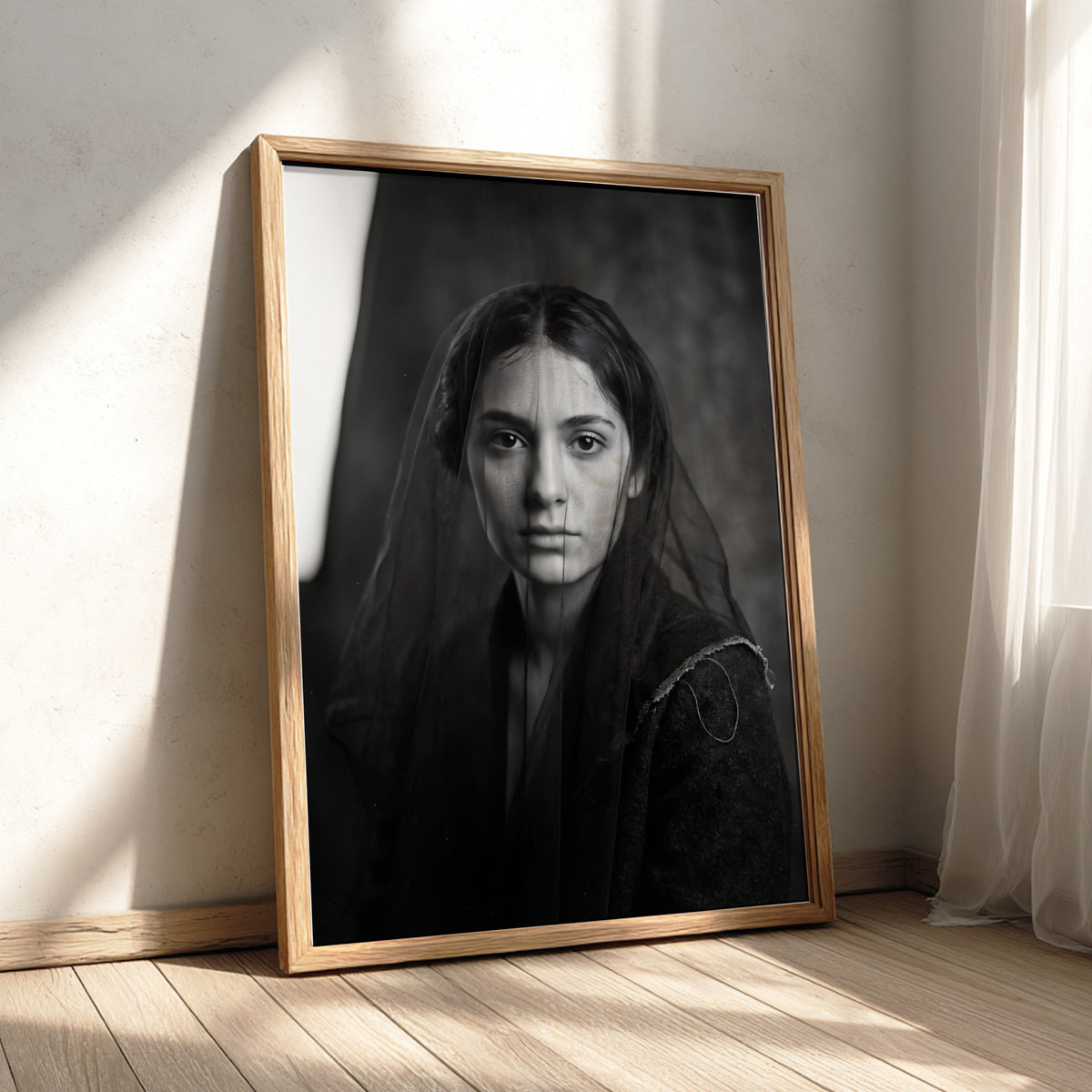 Black and white portrait wall decor of a model behind a sheer veil with soft shadows
