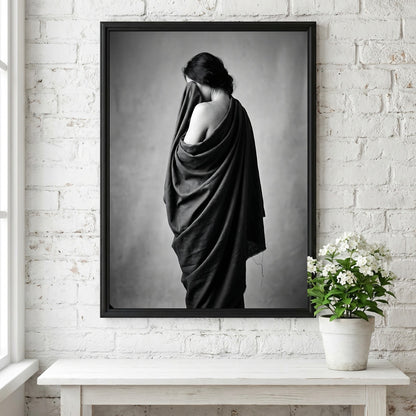 Black and white wall decor of a model draped in flowing dark fabric with soft shadows