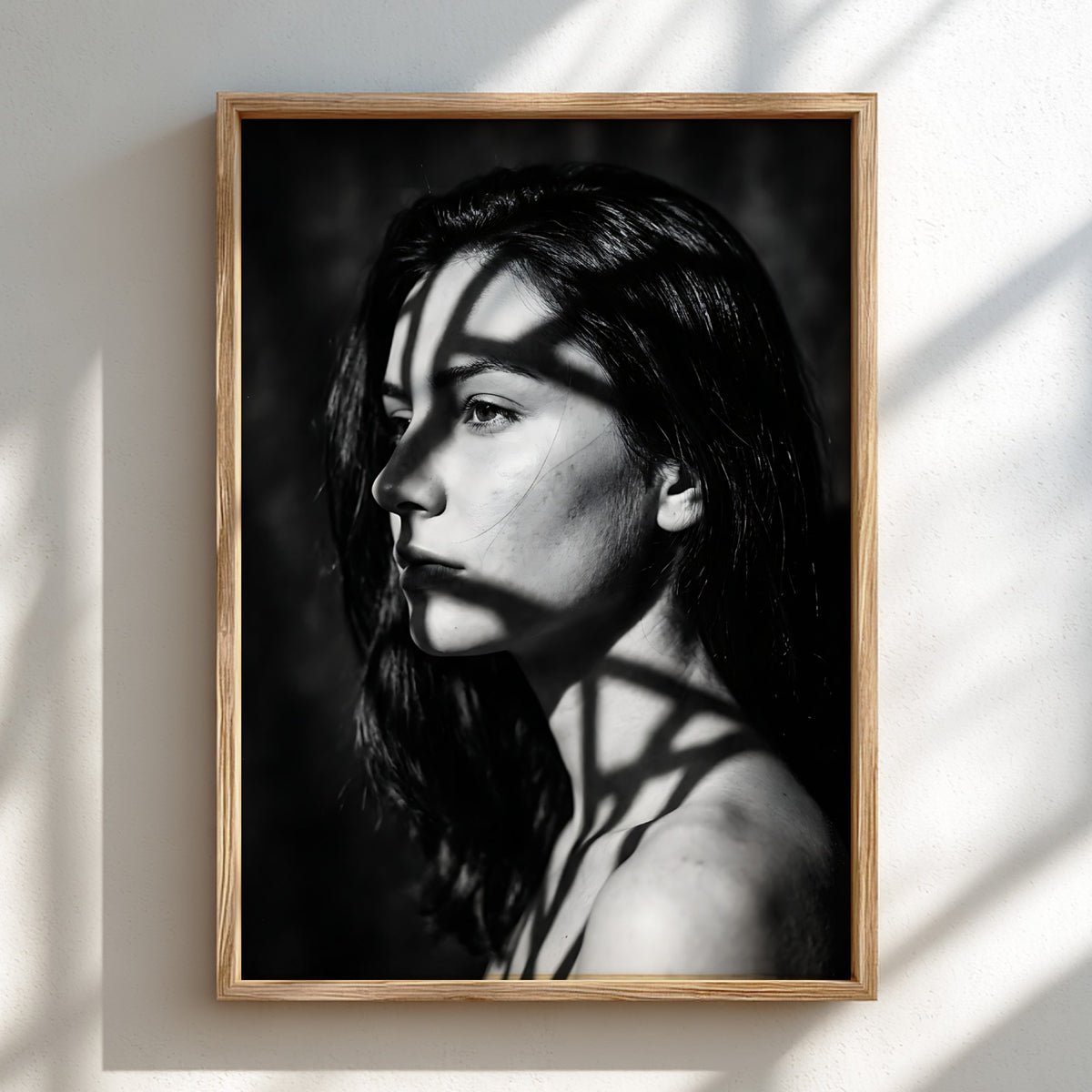 Black and white portrait wall decor of model lit by patterned gobo casting shadows