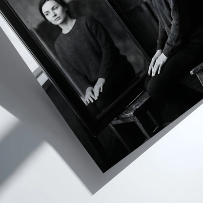 Black and white photographic poster of a woman sitting beside a mirror reflecting her calm face