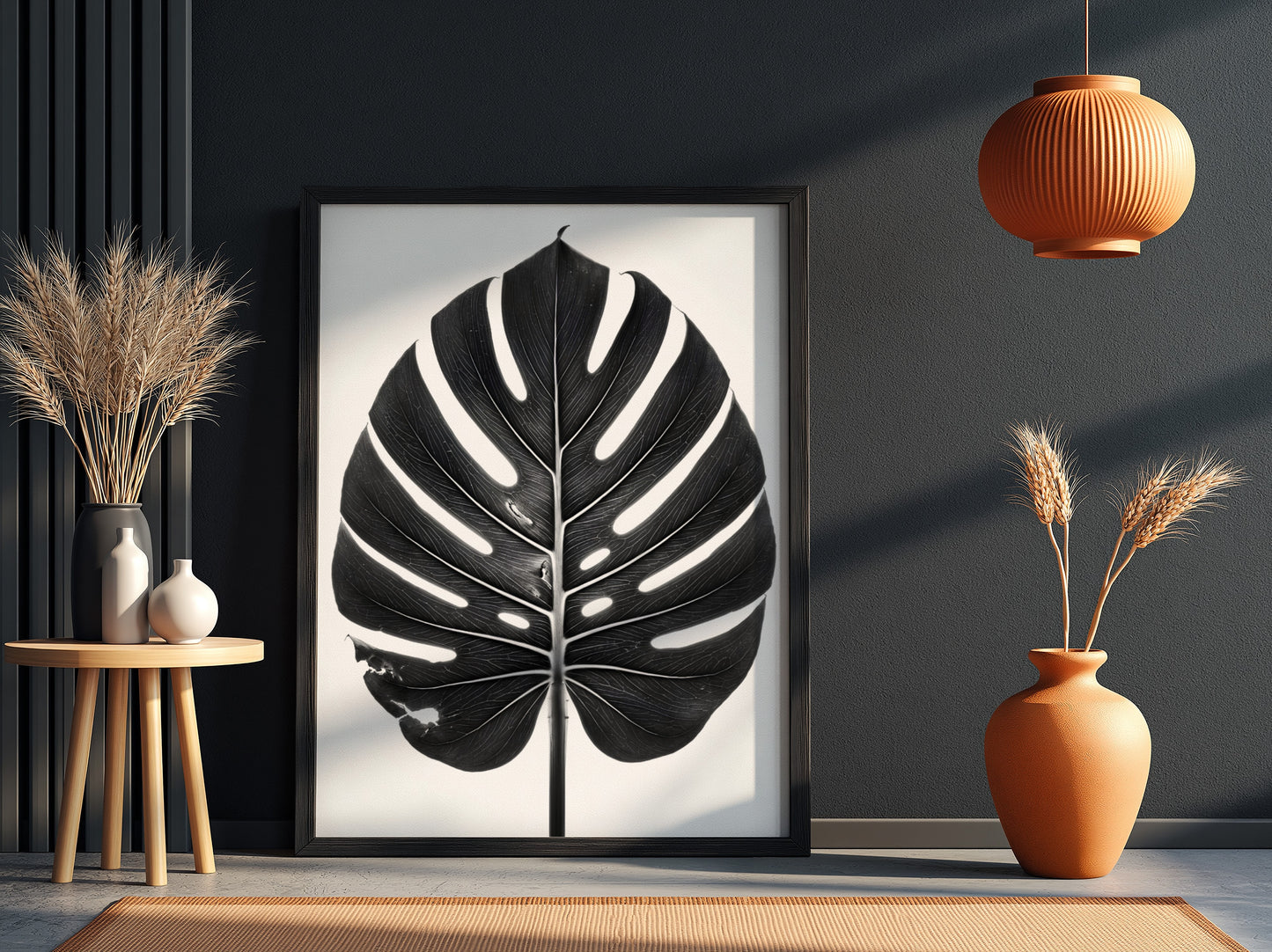 Wall decor featuring a black Monstera leaf with backlit studio effect and natural wood frame on white