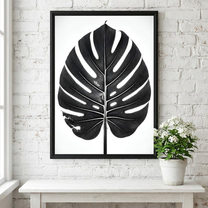 Wall decor featuring a black Monstera leaf with backlit studio effect and natural wood frame on white