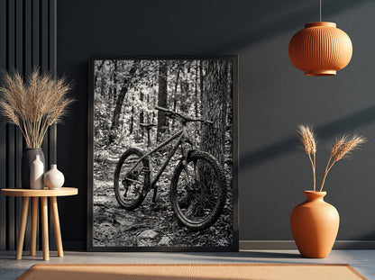 Black and white wall decor showing mountain bike resting against tree in forest with textured bark