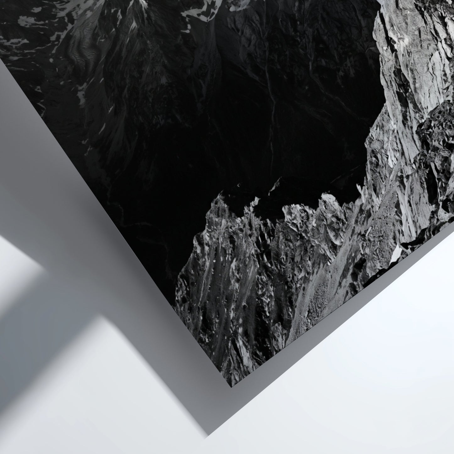 Black and white poster of mountain peak catching light with rugged rocky texture