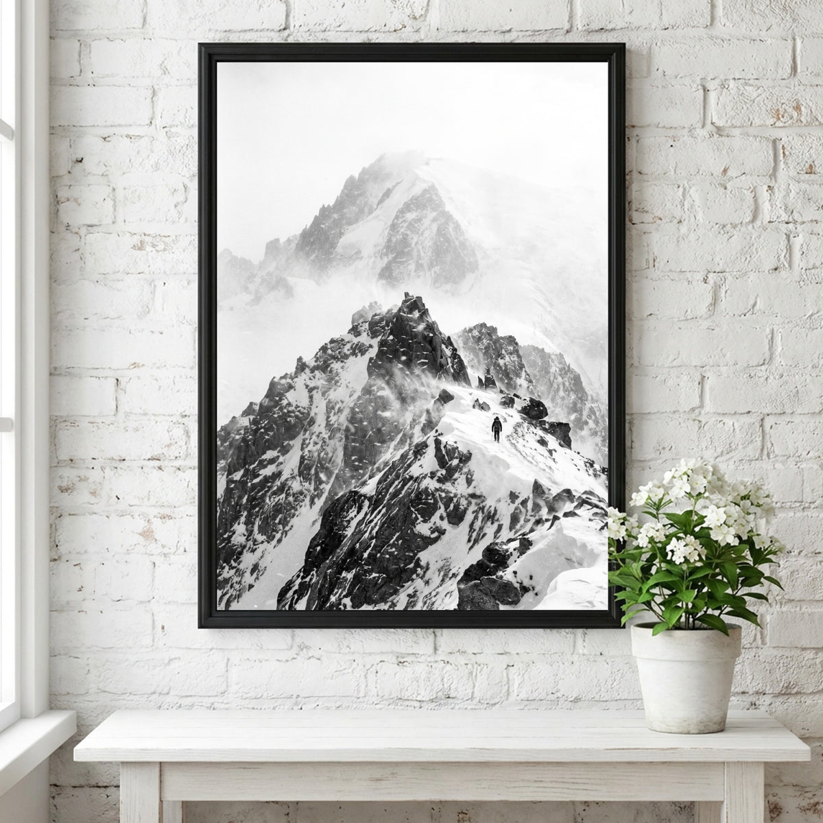 Black and white wall decor showing mountain ridge with blowing snow and rocky peaks in mist