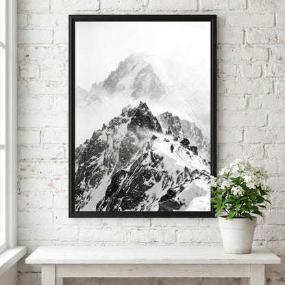 Black and white wall decor showing mountain ridge with blowing snow and rocky peaks in mist